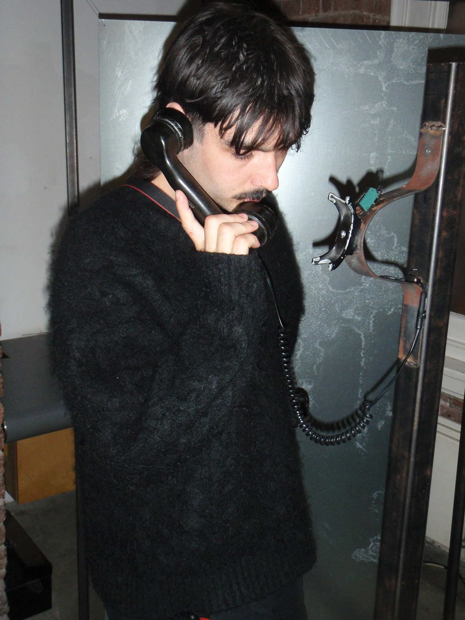 Phone on a metal pole with a red light ontop of it